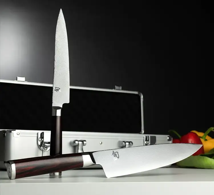 The Kohen Knife set is propped on a table in front of its carrying case.