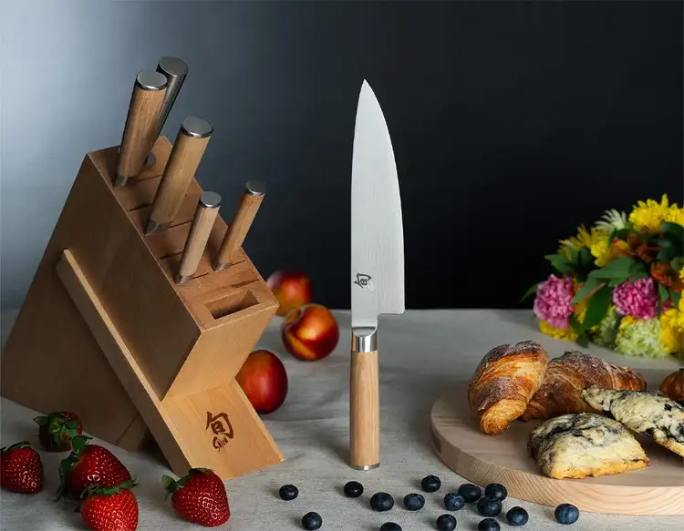 A Classic Blonde Knife Block sits on a table next to breakfast pastries. The Chef's Knife stands vertically in the middle of the table.